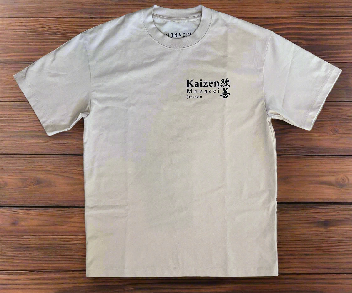 Beige t-shirt with 'Kaizen Monacci' logo on a wooden surface