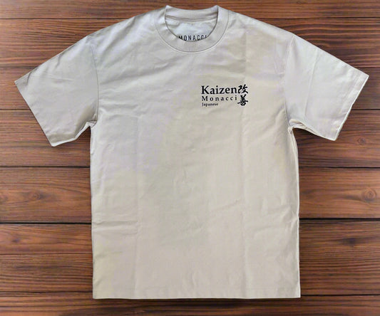 Beige t-shirt with 'Kaizen Monacci' logo on a wooden surface